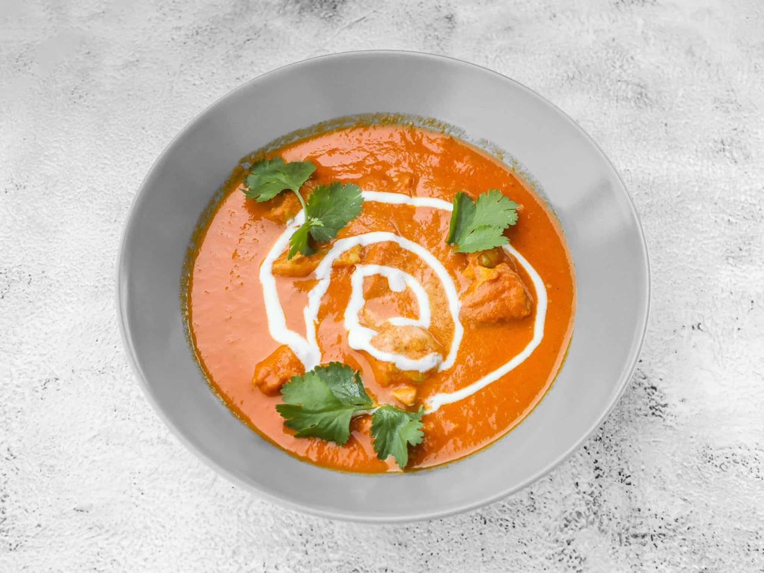 Butter chicken serveret i skål med koriander